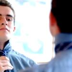 Young man fixing tie before temporary job interview